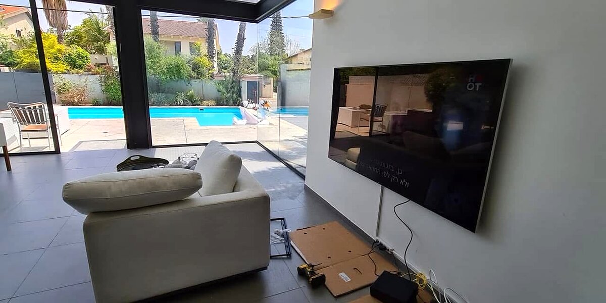 התקנת מסך ואודיו בוילה בקיסריה, סלון עם קיר זכוכית לבריכה, סימפל קיי